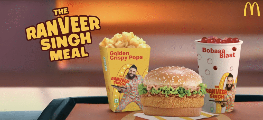 Display of McDonald's Ranveer Singh Meal components: Golden Crispy Pops, Bobaaa Blast, and a burger on a tray, overlain with bold campaign text.